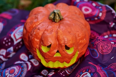 orange jack o lantern on red and black textile